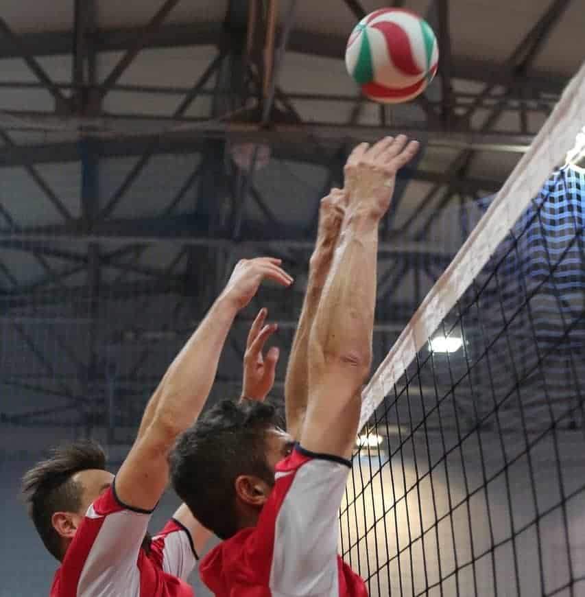 Two players blocking the volleyball