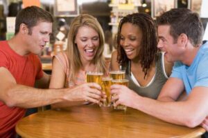 2 women and 2 men toasting with beer glasses