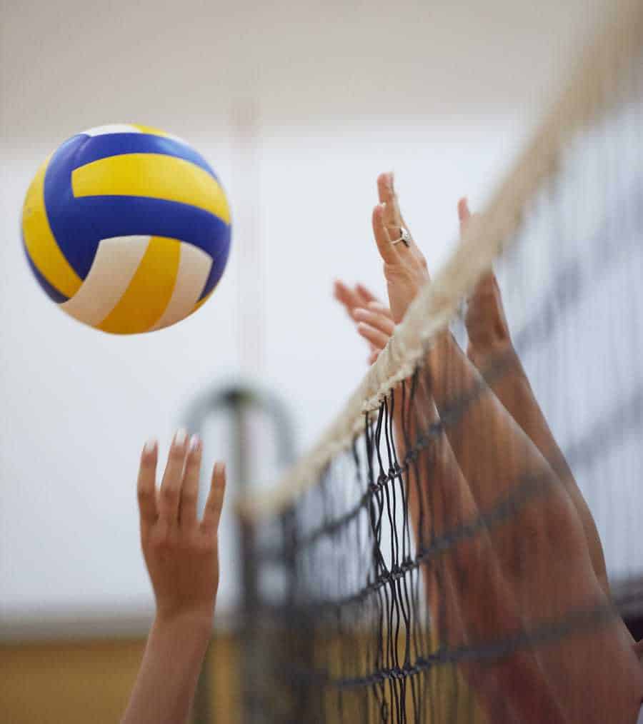 player tipping the volleyball over a block at the net