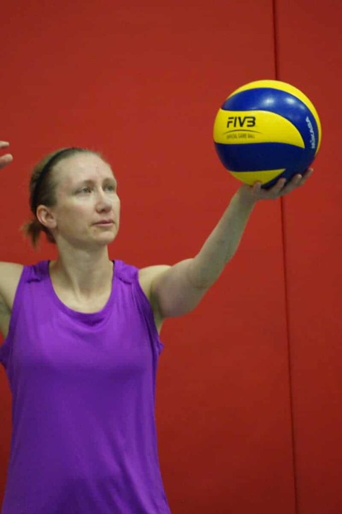 female volleyball player serving the volleyball