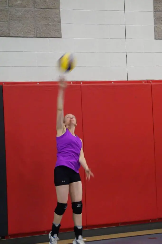 female volleyball player serving the volleyball