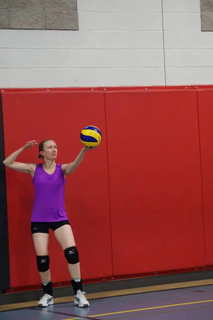 female volleyball player serving the volleyball