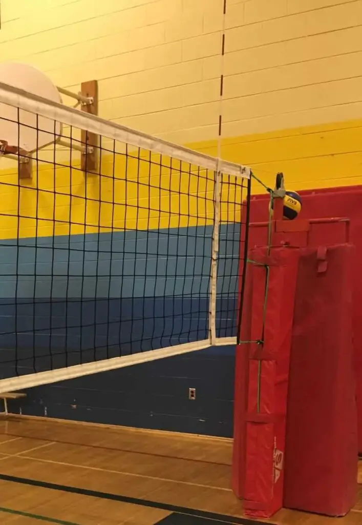 volleyball net and ref stand with volleyball perched on top