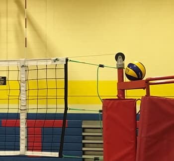 volleyball ref stand with volleyball perched on top and part of net showing