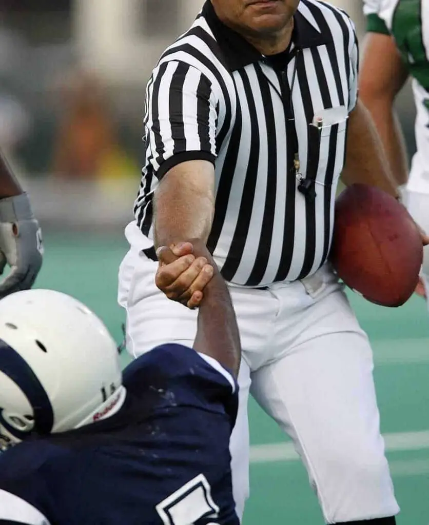 football referee helping up a player