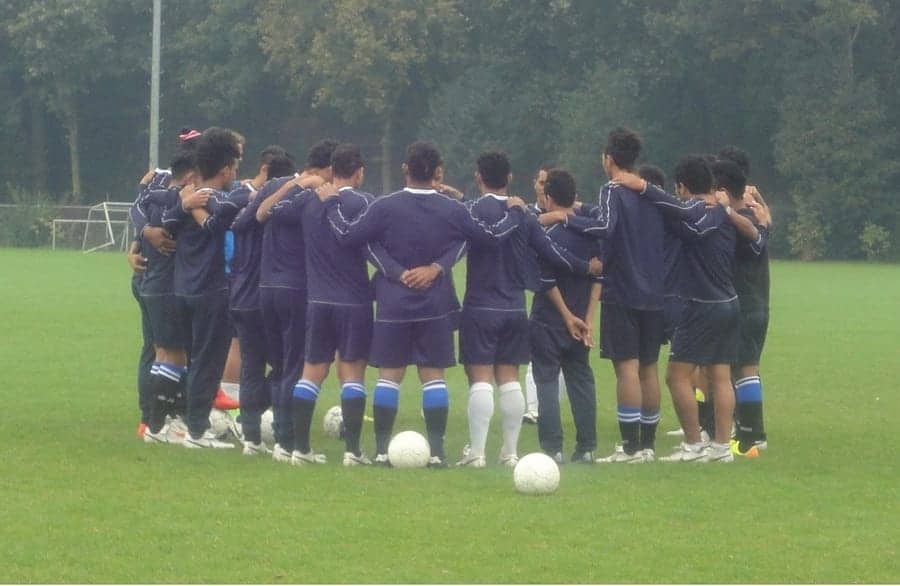 male soccer team in a huddle