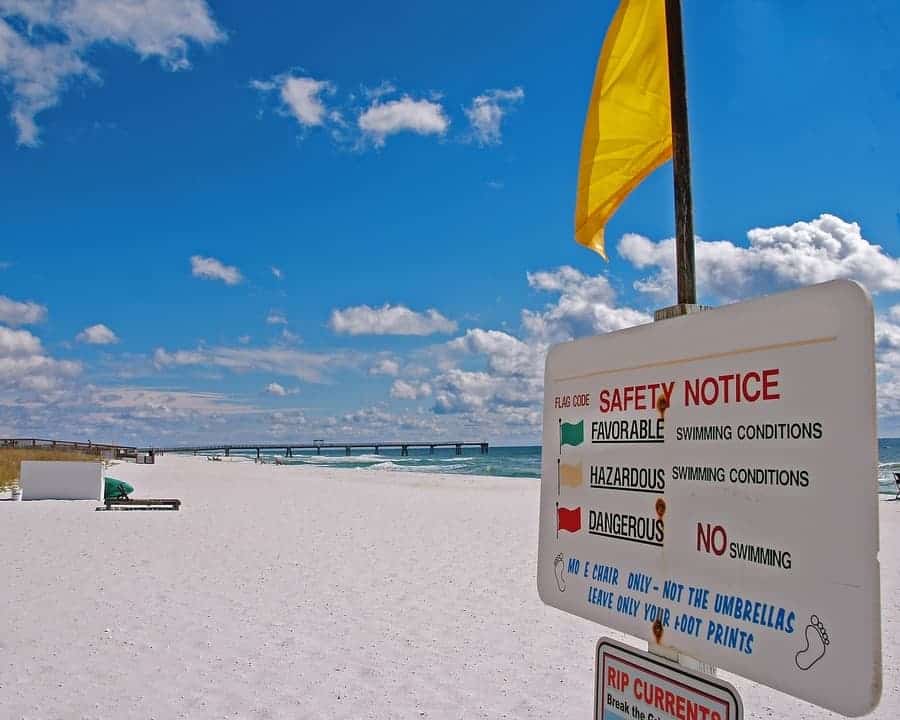 beach safety notice sign with yellow flag