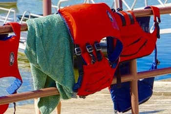 three life jackets drying on railing