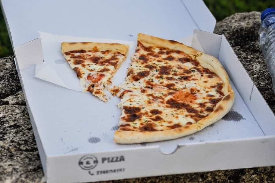 half a takeout pizza in a cardboard box