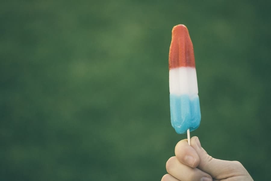 close up of a person holding a single popsicle
