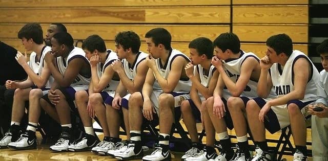 Basket ball team sitting on bench