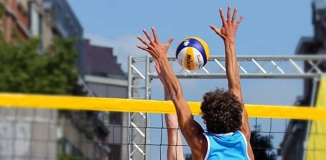 volleyball player blocking ball at net