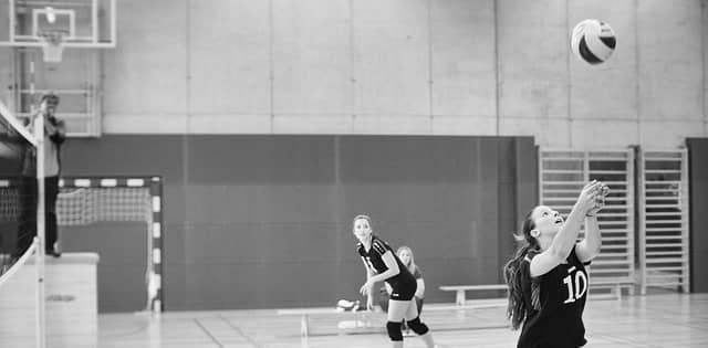 2 teammates playing volleyball