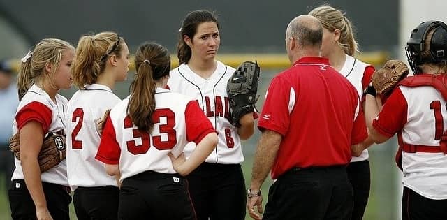 Coach talking to softball team