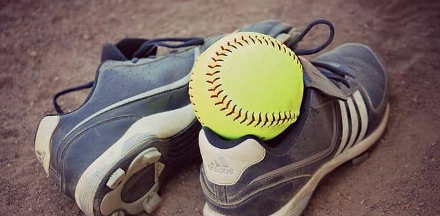 Cleats with softball sitting on top