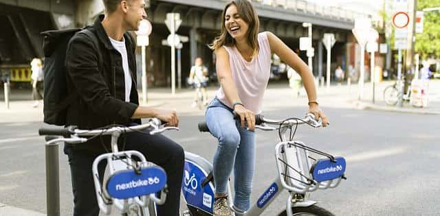 Two people riding bikes in a city street